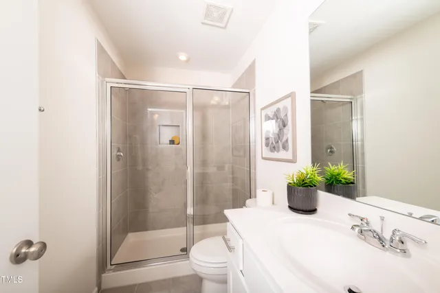 a bedroom with a large bed and a flat tv screen on dresser