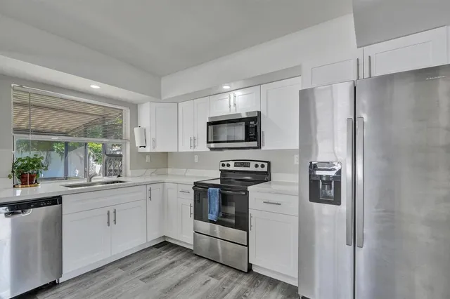 a kitchen with stainless steel appliances a refrigerator stove and sink