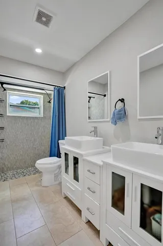 a bathroom with a toilet sink and mirror