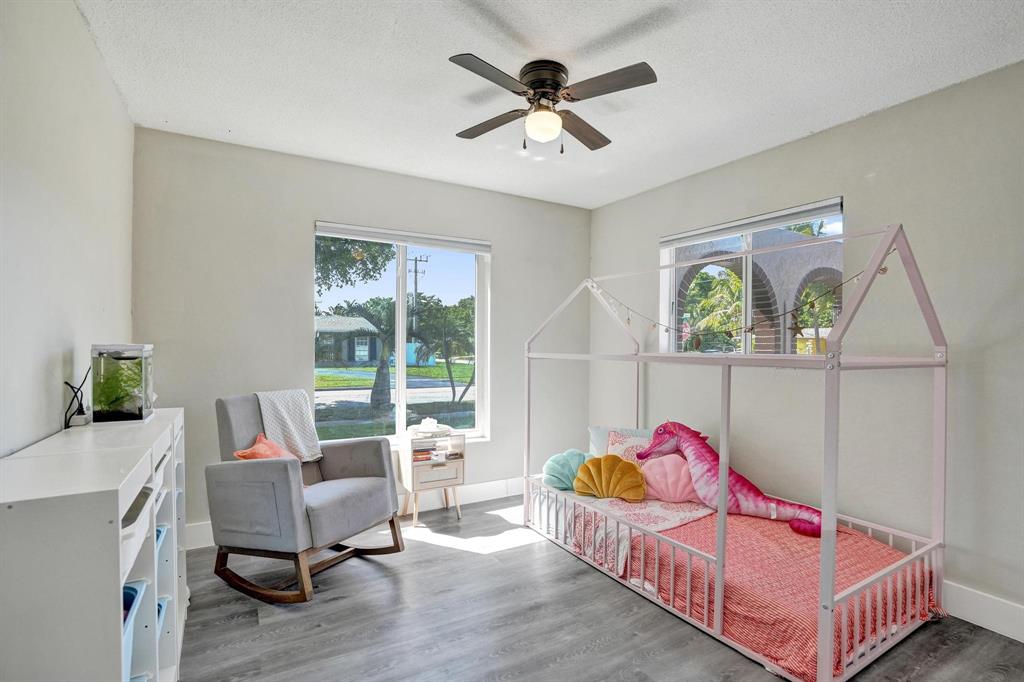 6411 Southwest 6th Street Margate, FL 33068 - Photo 25 of 48 a bedroom with a bed and a chandelier