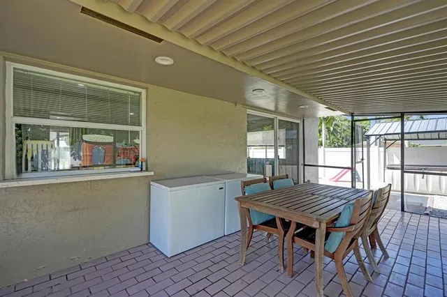a wooden table and chairs in patio of a house