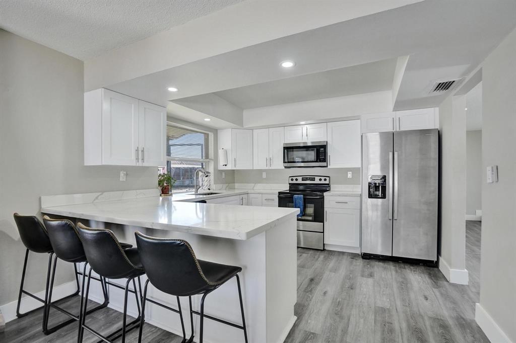 6411 Southwest 6th Street Margate, FL 33068 - Photo 4 of 48 a kitchen with kitchen island white cabinets and stainless steel appliances