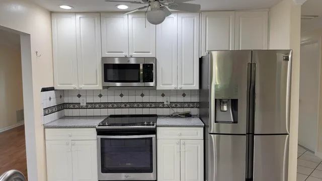 a kitchen with a refrigerator sink and cabinets