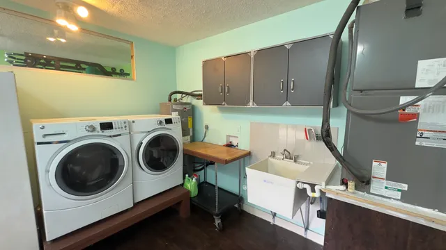 a utility room with dryer washer and a view of living room