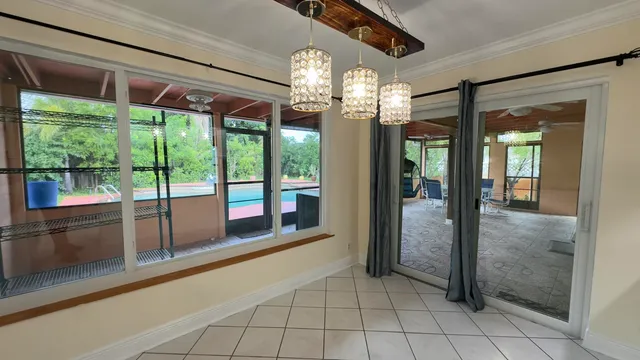 a room with chandelier and large glass windows