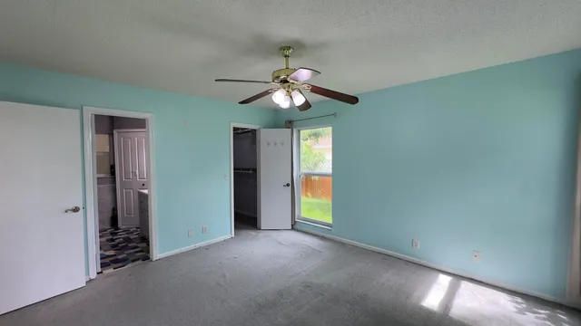 a view of a room with a ceiling fan and a window