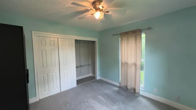 a view of a room with a ceiling fan and a bathroom
