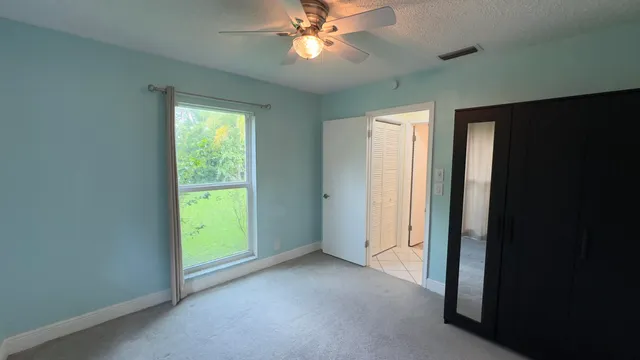 a view of a livingroom with a chandelier fan and a window