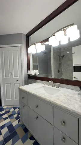 a bathroom with a granite countertop sink and a mirror