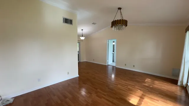 a view of a room with wooden floor and ceiling fan