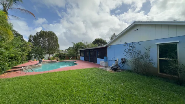 a view of a backyard with table and chairs and wooden fence