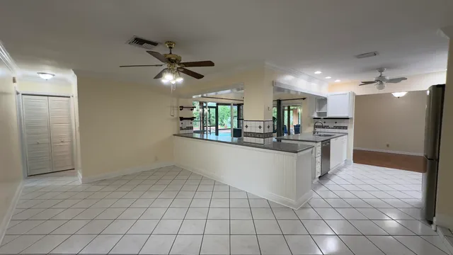 a kitchen with stainless steel appliances kitchen island granite countertop a refrigerator and a stove top oven