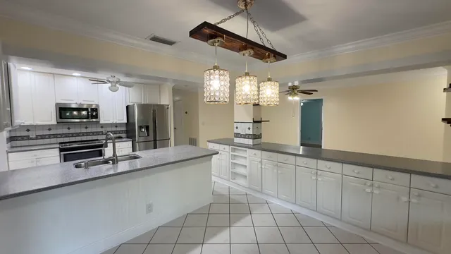 a large kitchen with a large counter space appliances and cabinets