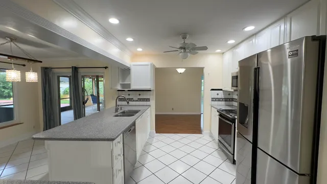 a kitchen with stainless steel appliances granite countertop a refrigerator and a stove top oven