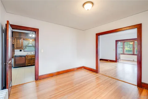 a view of a room with wooden floor and a kitchen