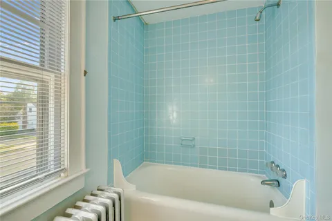 a bathroom with a bathtub and window