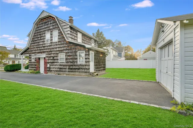 a view of a big house with a big yard and large tree