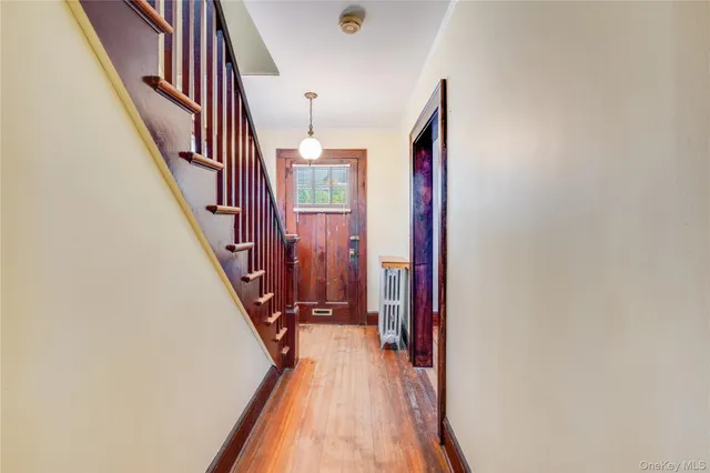 a view of a hallway with wooden floor and stairs