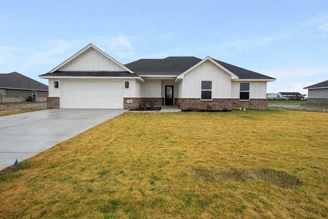 a view of a house with a yard and garage