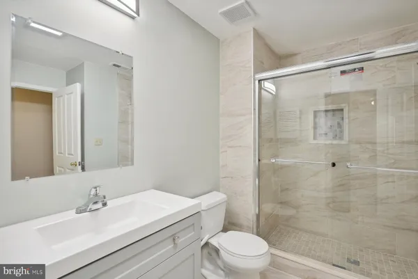 a bathroom with a sink mirror toilet and shower