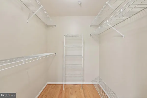 a view of walk in closet with empty racks