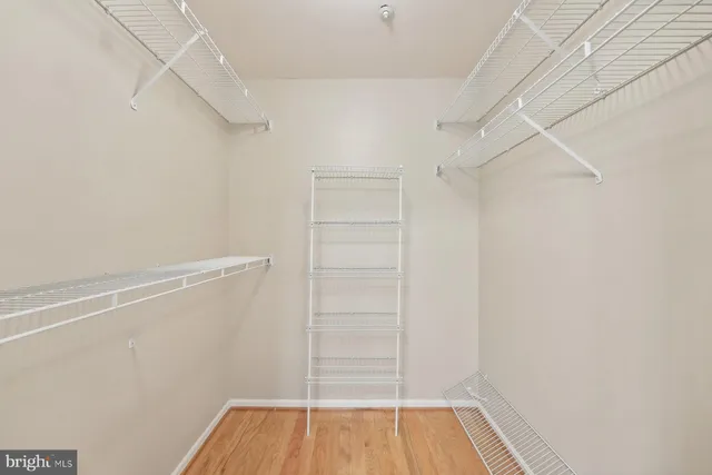 a view of walk in closet with empty racks