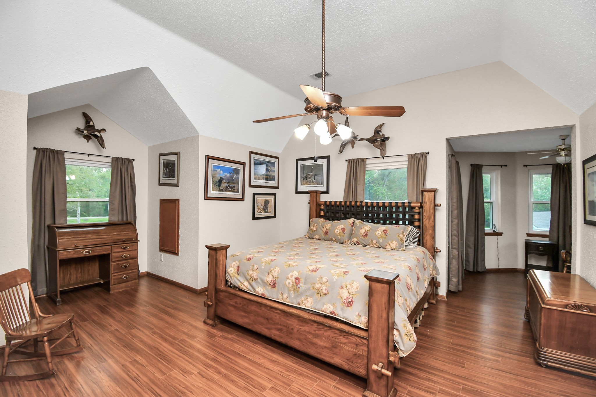 20202 Deer Run Road Damon, TX 77430 - Photo 29 of 45 a bedroom with a large bed chandelier and a window