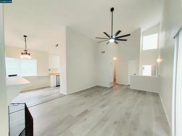 a view of an empty room with a ceiling fan and a window