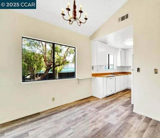 a view of kitchen with wooden floor and electronic appliances