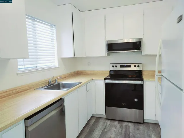 a kitchen with stainless steel appliances a stove sink and microwave