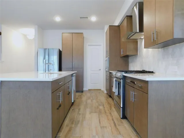 a kitchen with stainless steel appliances a sink stove and refrigerator