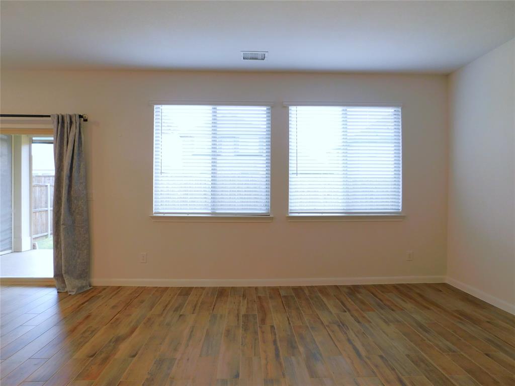 1111 Saddle Ridge Drive Aubrey, TX 76227 - Photo 13 of 35 an empty room with wooden floor and windows
