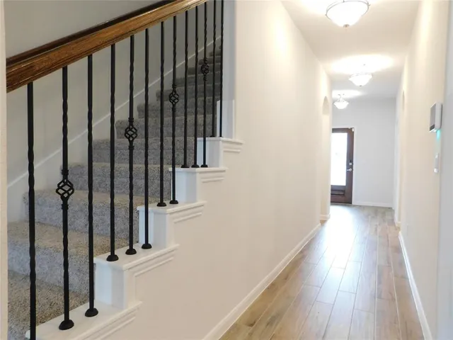 a view of a hallway with wooden floor and staircase
