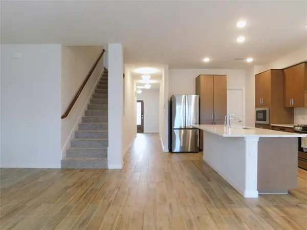 a kitchen with stainless steel appliances wooden floor and large windows