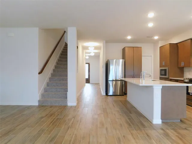 a kitchen with stainless steel appliances wooden floor and large windows