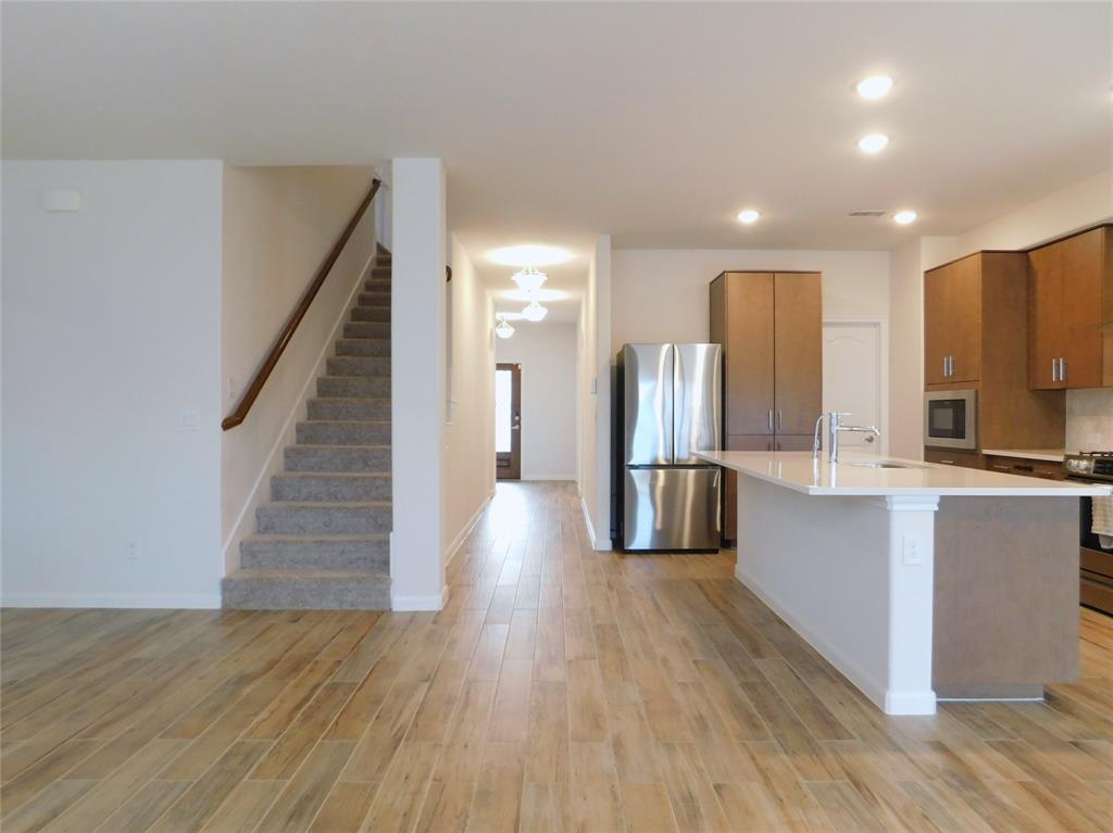 1111 Saddle Ridge Drive Aubrey, TX 76227 - Photo 8 of 35 a kitchen with stainless steel appliances wooden floor and large windows