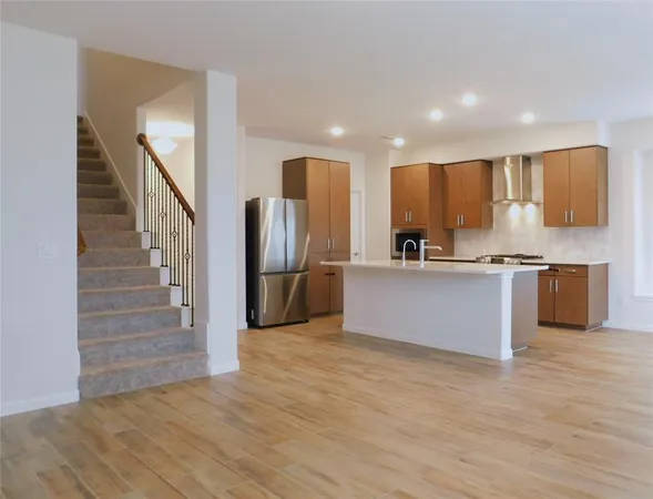 a kitchen with stainless steel appliances a refrigerator and a stove top oven