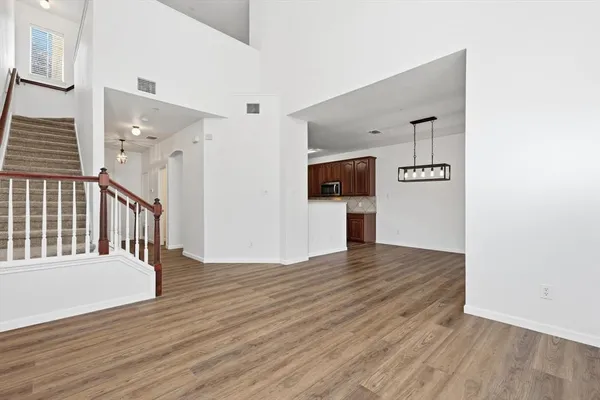 a view of a hallway with wooden floor and staircase