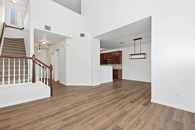 a view of a hallway with wooden floor and staircase