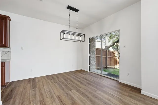 a view of a room with wooden floor staircase and a chandelier