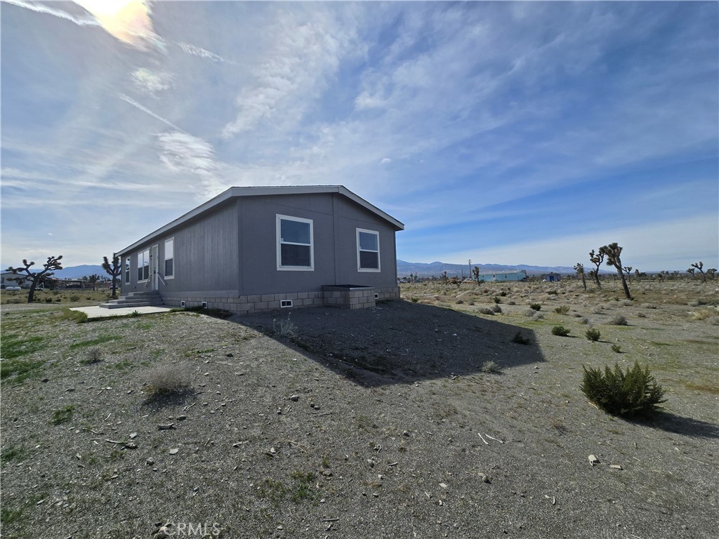 12474 Silver Rock Road Pinon Hills, CA 92372 - Photo 26 of 34 a view of a dry yard with a house