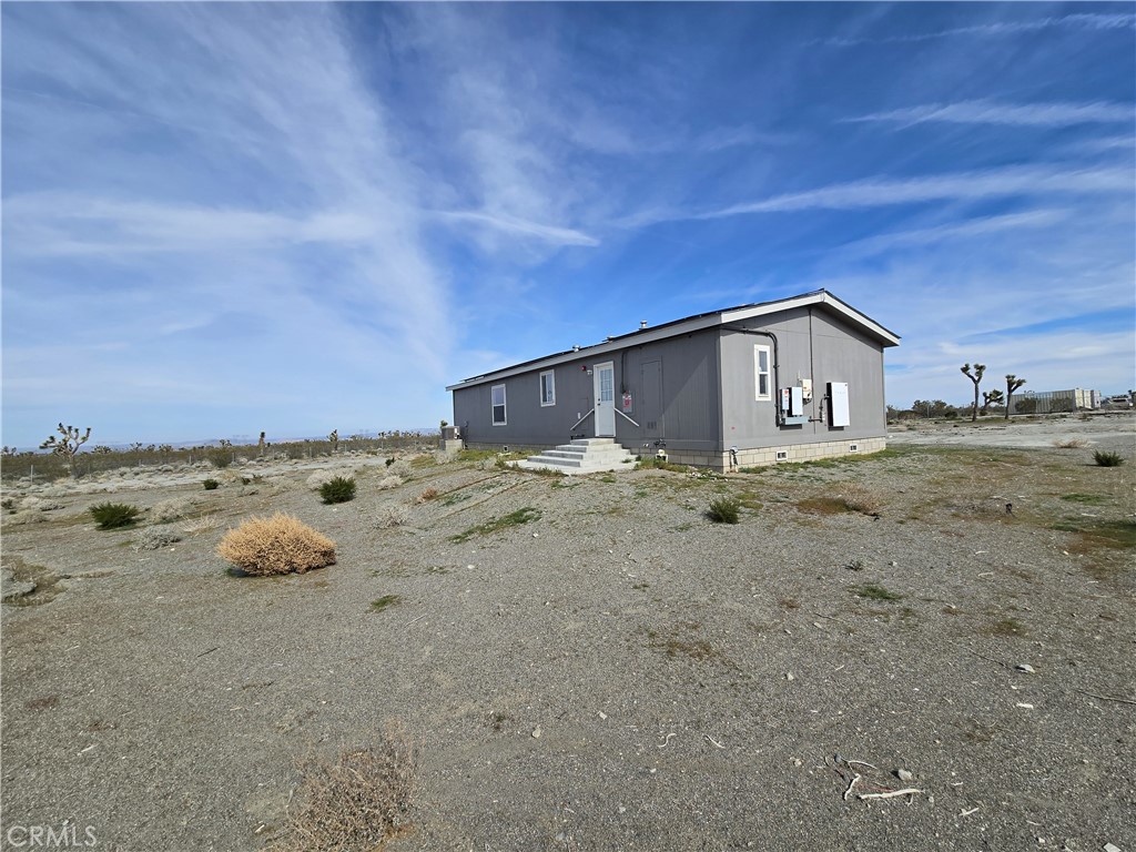 12474 Silver Rock Road Pinon Hills, CA 92372 - Photo 4 of 34 a view of a dry yard with a large tree