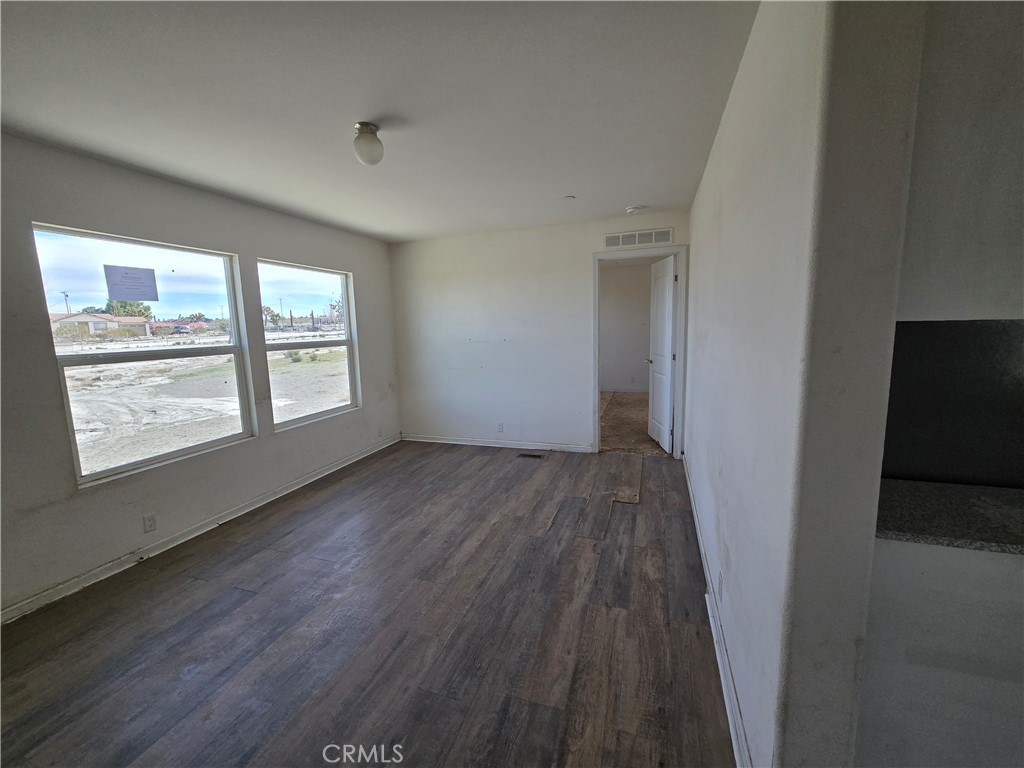 12474 Silver Rock Road Pinon Hills, CA 92372 - Photo 7 of 34 an empty room with wooden floor and windows