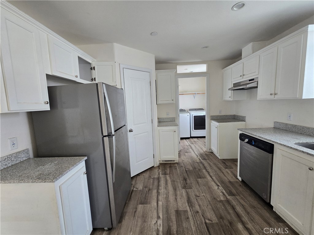 12474 Silver Rock Road Pinon Hills, CA 92372 - Photo 9 of 34 a kitchen with a refrigerator stove and wooden cabinets