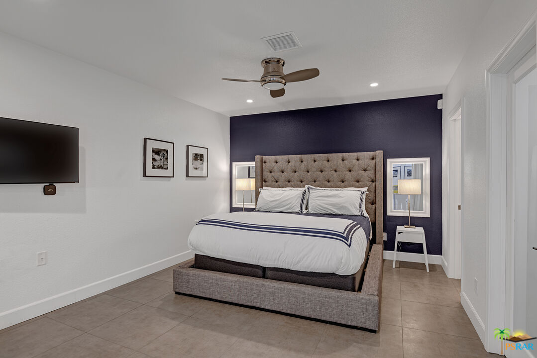 1530 North Kaweah Road Palm Springs, CA 92262 - Photo 26 of 42 a spacious bedroom with a bed and a flat screen tv