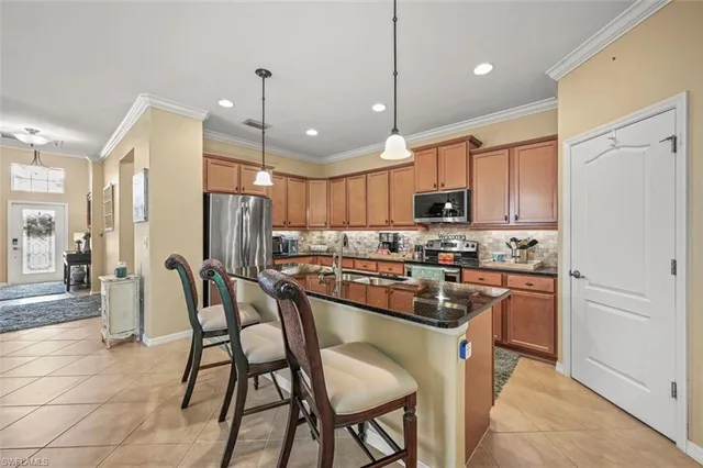 a kitchen with stainless steel appliances granite countertop a sink refrigerator and cabinets