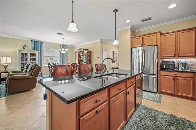 a kitchen with kitchen island a dining table chairs stainless steel appliances and cabinets