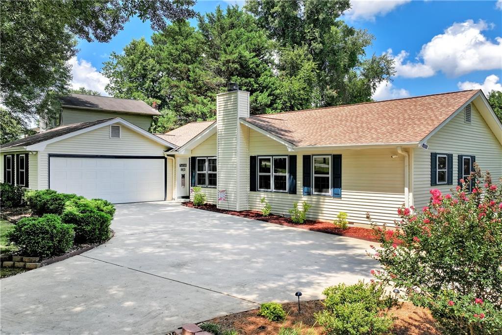 5658 Raintree Trace Oakwood, GA 30566 - Photo 2 of 55 a front view of a house with a garden and trees