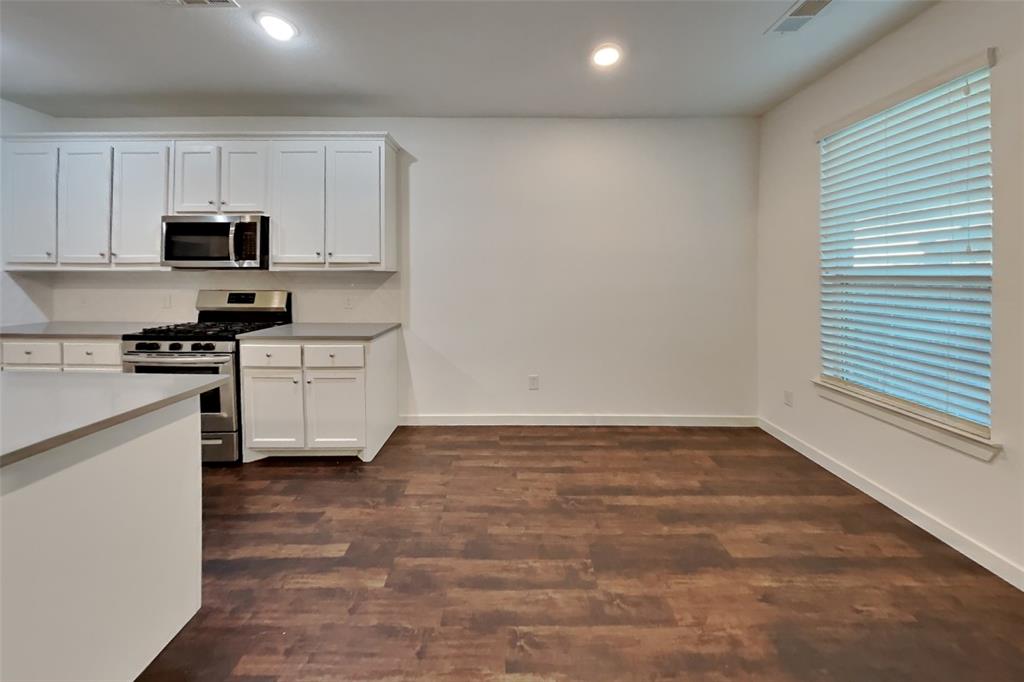 1538 Calcot Lane Forney, TX 75126 - Photo 4 of 21 a kitchen with granite countertop white cabinets and white appliances