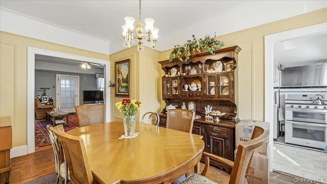 a dining room with furniture a chandelier and wooden floor
